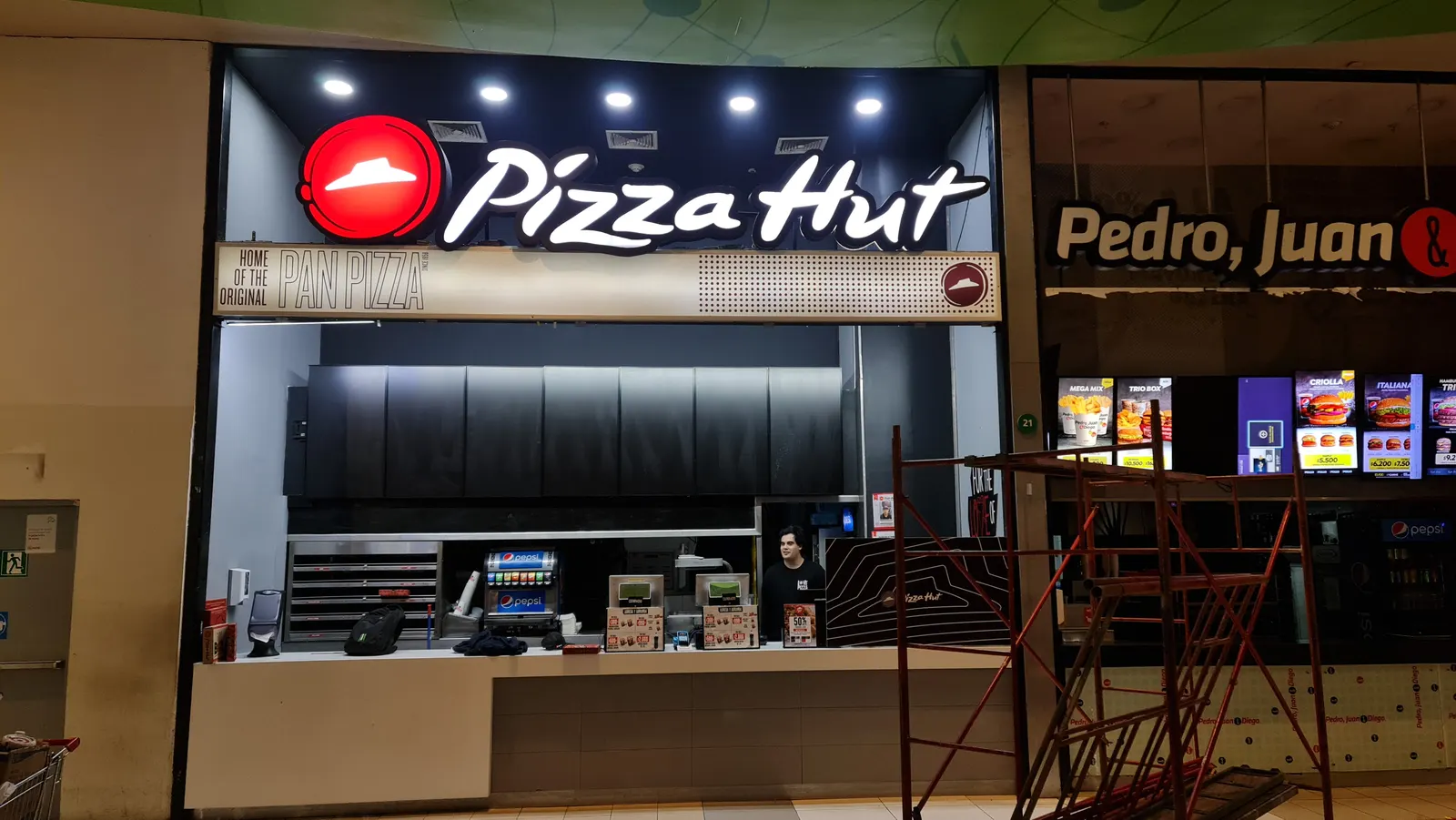 Letrero Pizza Hut iluminado sobre el mesón